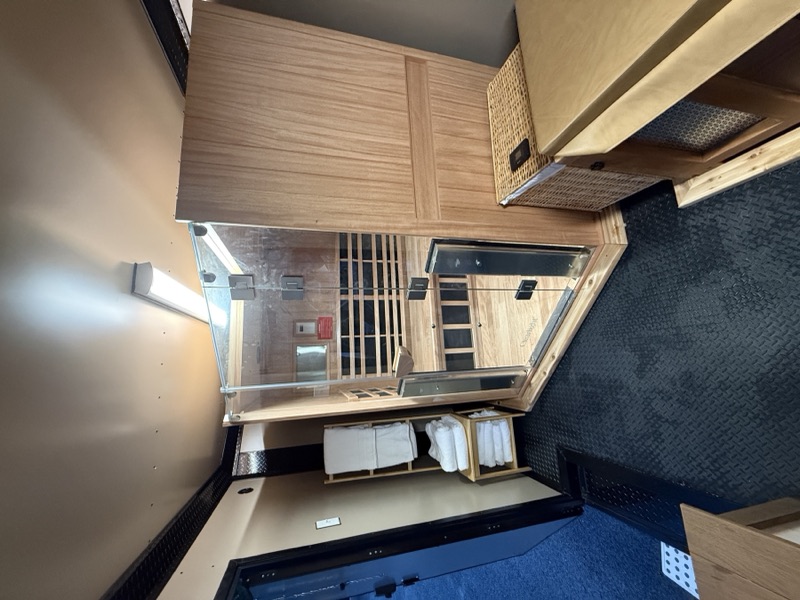 Close-up of the Clearlight infrared sauna with cubbies of fresh towels